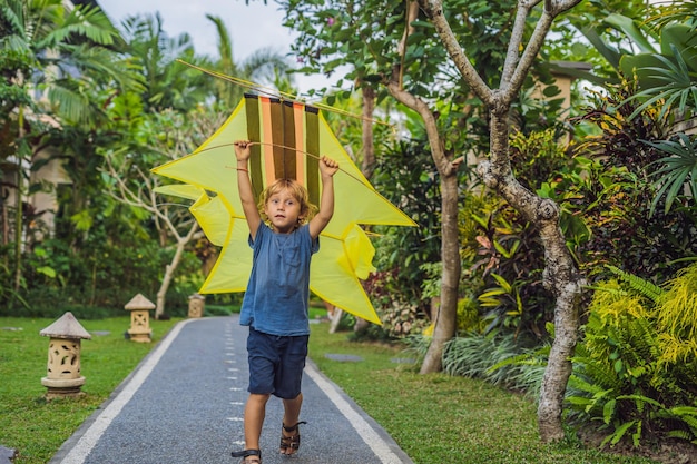 Junge startet einen Drachen im Park in Ubud, Insel Bali, Indonesien