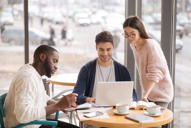 Junge Startups. Gruppe von Jugendlichen, die sich im Café treffen und wichtige Momente gemeinsam besprechen.