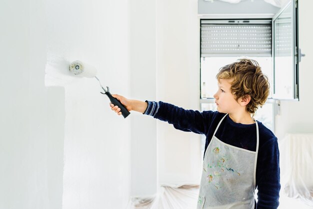 Foto junge steht zu hause an der weißen wand