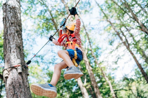 Junge steigt das Kabel zur Holzplattform hinab