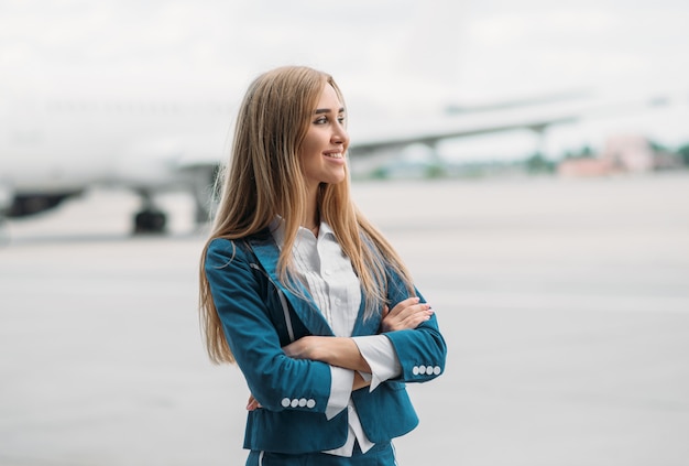 Junge Stewardess in Uniform auf Flugzeugparkplatz