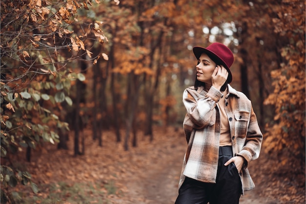 Junge stilvolle Frau in einem trockenen Herbstwald