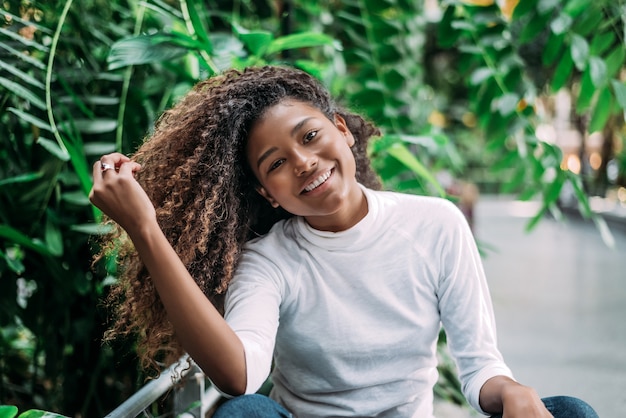 Junge stilvolle schwarze Frau mit dem Afrofrisurlächeln.