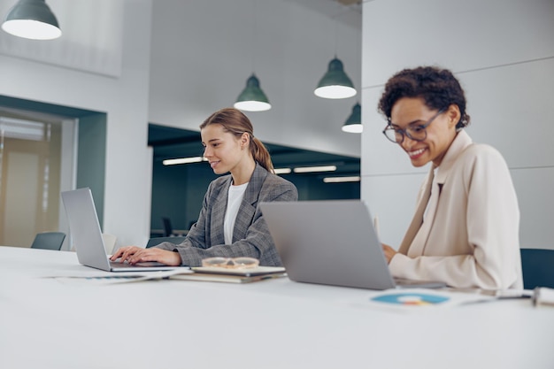 Junge, stilvolle Vertriebsleiterinnen arbeiten zusammen in einem Coworking-Büro