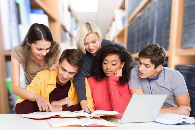 Junge Studenten, die auf Bibliothekshintergrund studieren