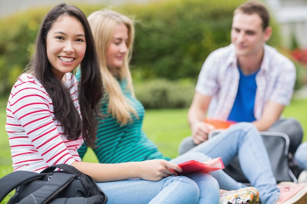 Junge Studenten, die im Park sitzen