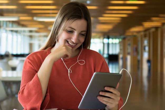 Junge Studentin, die in der Bibliothek studiert.