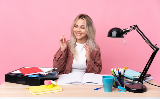 Junge Studentin, die in einem lachenden Tisch arbeitet