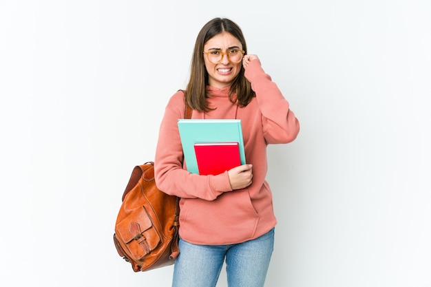 Junge Studentin, die Ohren mit Händen bedeckt