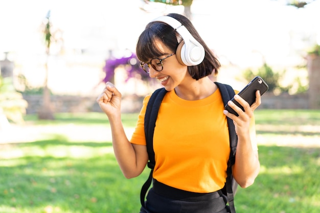 Junge Studentin gewinnt einen Park mit Handy