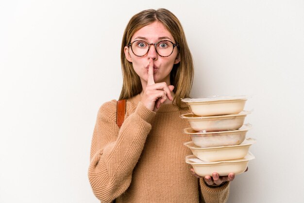 Foto junge studentin hält einen topper isoliert auf weißem hintergrund, der ein geheimnis bewahrt oder um stille bittet