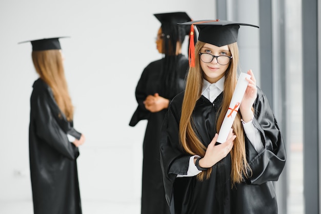 Junge Studentin im Gewand feiert ihren Abschluss