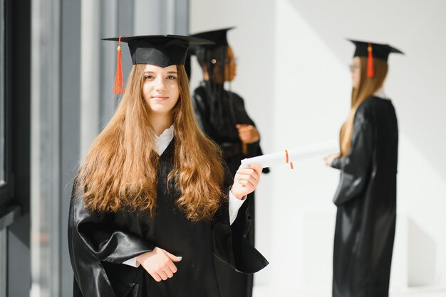 Junge Studentin im Gewand feiert ihren Abschluss