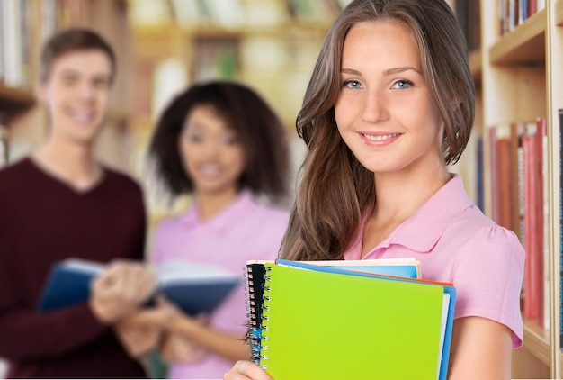 Junge Studentin mit Büchern im Hintergrund