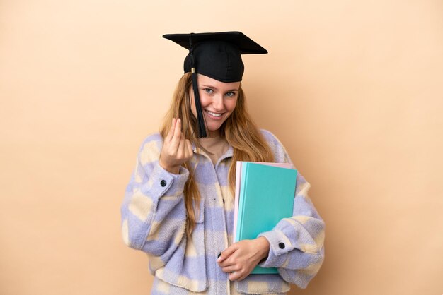 Junge Studentin mit isoliertem Hintergrund, die Geldgeste macht