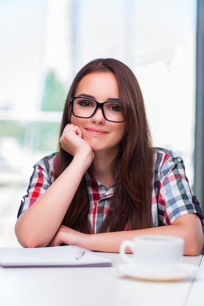 Junge Studentin mit vielen Büchern