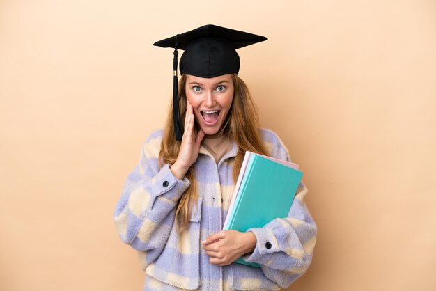 Foto junge studentin vor isoliertem hintergrund mit überraschtem und schockiertem gesichtsausdruck