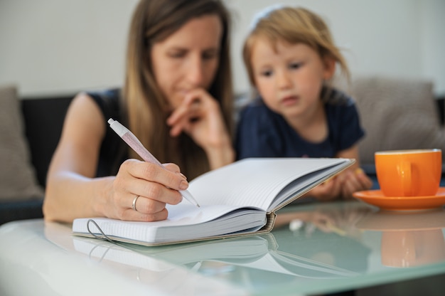 Junge studentische Mutter, die von zu Hause aus studiert