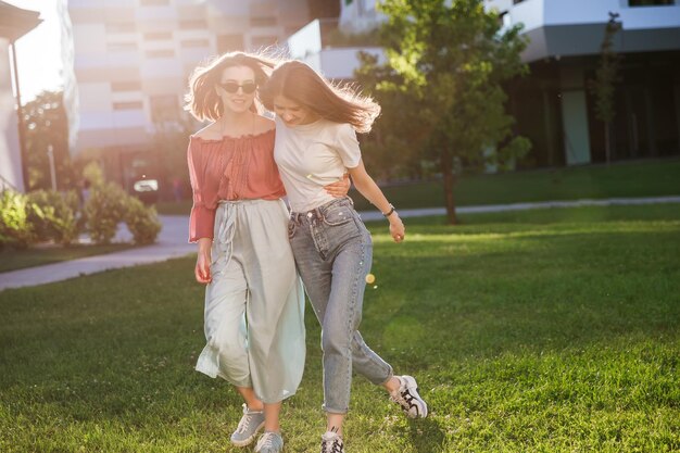 Junge talentierte Studentinnen in Freizeitkleidung laufen durch den Park