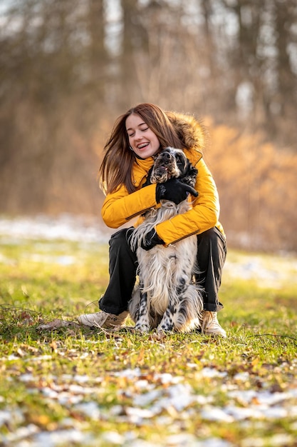 Junge Teenager-Mädchen spielt mit ihrem Hund in der Natur englischer Setter