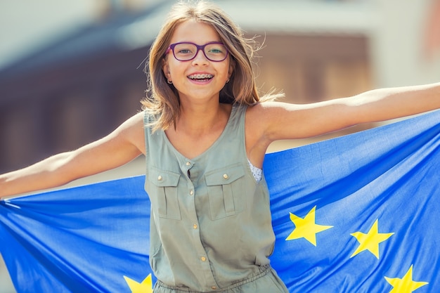 Junge Teenager-Mädchen winken mit der Flagge der Europäischen Union in der Stadt