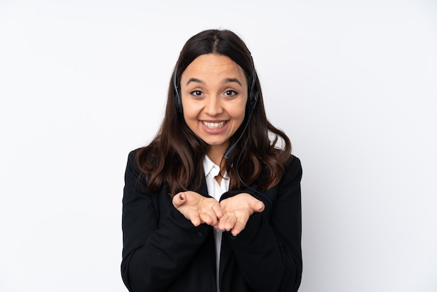 Junge Telemarketerfrau auf weißer Wand, die Leerzeichen auf der Handfläche hält