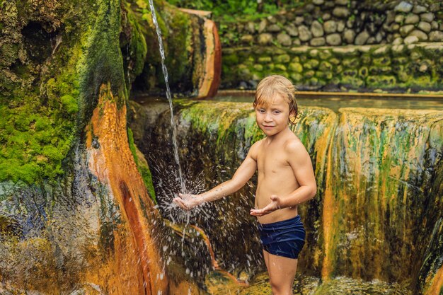 Junge Touristen in den heißen Quellen von Belulang auf Bali, Dorf Mengesta, Distrikt Penebel, Regentschaft Tabanan. Reisen mit Kinderkonzept