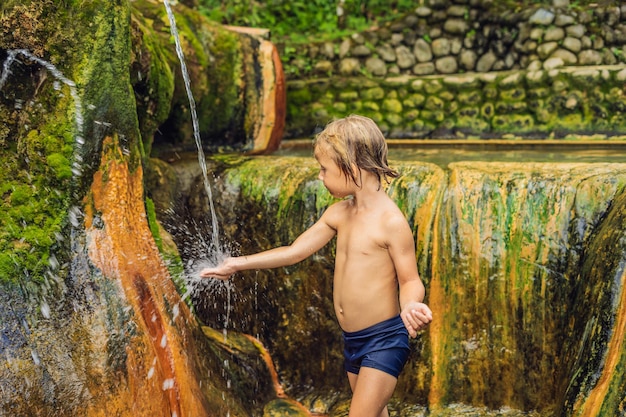 Junge Touristen in den heißen Quellen von Belulang auf Bali, Dorf Mengesta, Distrikt Penebel, Regentschaft Tabanan. Reisen mit Kinderkonzept