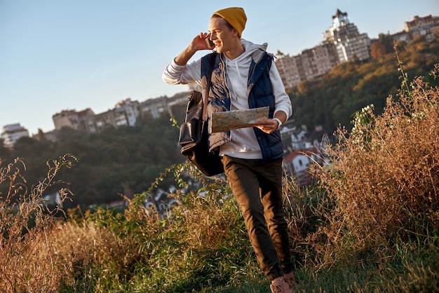 Junge Touristenbloggerin erkundet die Karte und telefoniert mit dem Smartphone