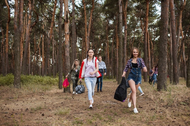 Junge Touristengruppe, die zusammen durch den Wald wandert. Lebensstil der Reisenden. Teamgeist.