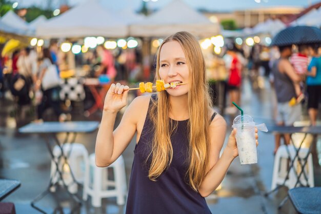 Junge Touristin auf dem asiatischen Lebensmittelmarkt der Walking Street