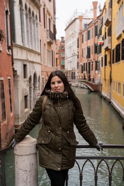 Foto junge touristin auf einer kanalbrücke in venedig inmitten farbenfroher fassaden