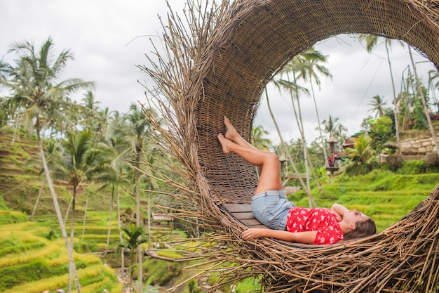 Junge Touristin, die ihre Reise um Bali Insel, Indonesien genießt. Fotografien in einem Strohnest, natürliche Umgebung.