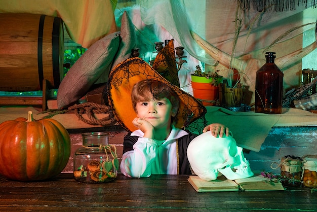 Junge trägt Halloween-Kostüm mit Kürbis ein altes Holzhaus Happy halloween süßer kleiner Junge macht ...