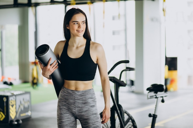 Junge Trainerin, die im Fitnessstudio trainiert