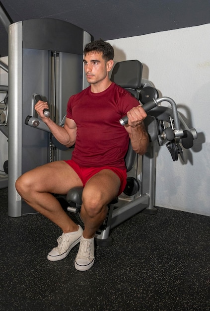 Junge trainiert seinen Bizeps im Fitnessstudio