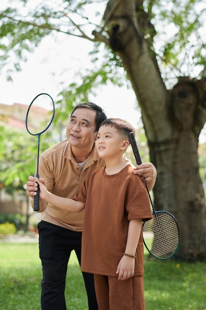 Junge und Großvater spielen Badminton