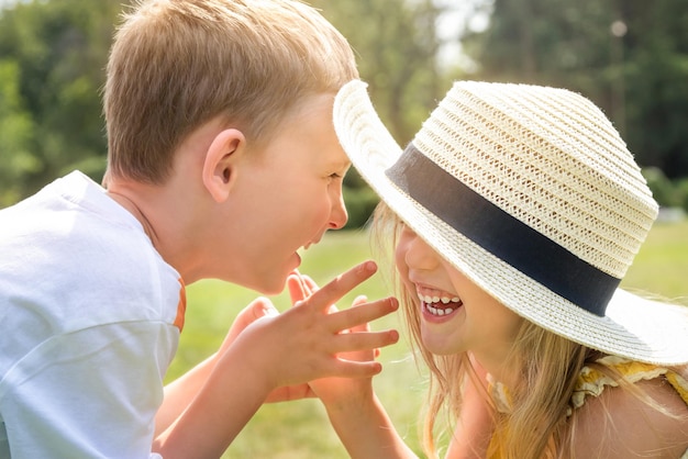 Junge und Mädchen, die an einem Sommertag im Freien spielen, lachen und Händchen halten, Nahaufnahme Glückliche Familie