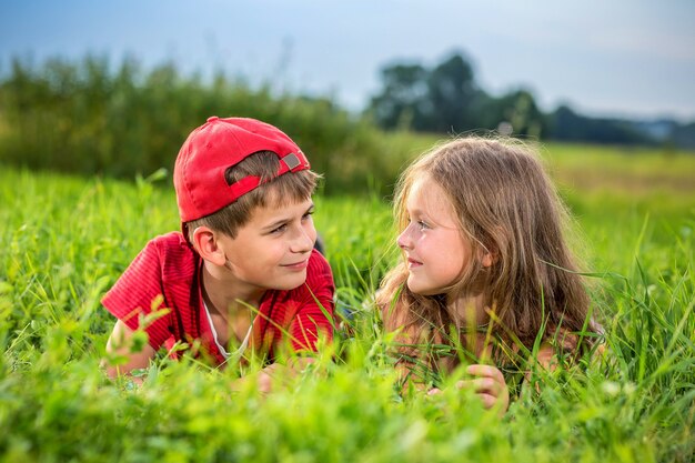 Junge und Mädchen, die auf Gras liegen