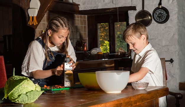 Junge und Mädchen, die in der Küche echtes Foto kochen