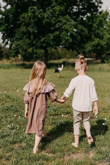 Junge und Mädchen gehen auf grünem Gras, barfuß