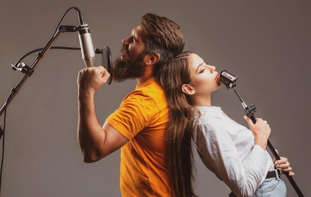 Junge und Mädchen mit aufgeregten Gesichtern genießen Musik Paar im Tonstudio Musikperformance Gesang Singen...