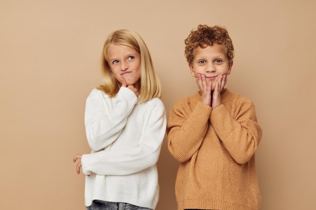 Junge und Mädchen stehen neben dem beigen Hintergrund der Emotionen