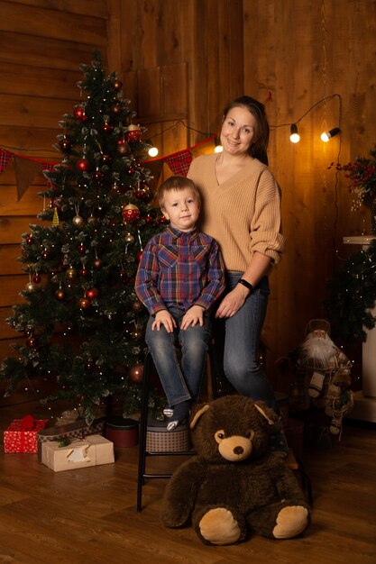 Junge und Mutter nahe Weihnachtsbaum zu Hause