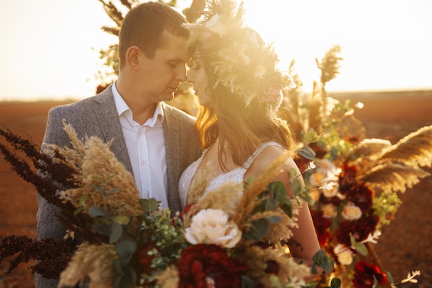 Junge und schöne Braut und Bräutigam genießen sich. Hochzeitstag im Boho-Stil.