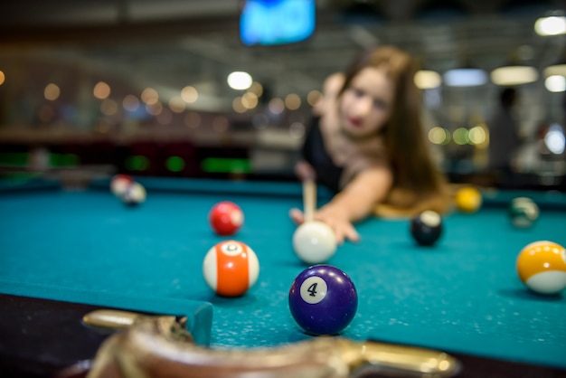 Junge und schöne Frau in der Kneipe, die Billard spielt