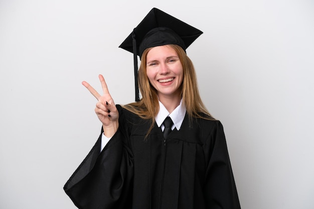 Junge Universitätsabsolventin Engländerin isoliert auf weißem Hintergrund lächelnd und Victory-Zeichen zeigend