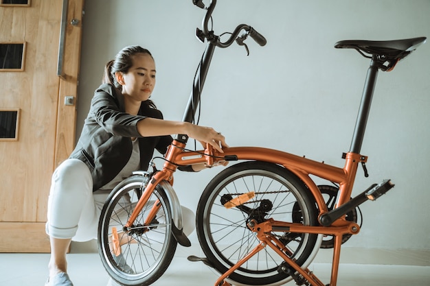 Junge unternehmerin bereitet ein faltrad von zu hause aus vor