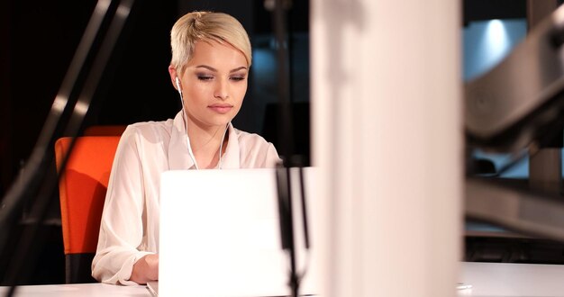 Foto junge unternehmerin, die im nachtbüro an einem laptop arbeitet