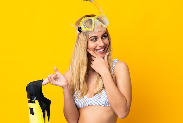 Junge uruguayische blonde Frau im Badeanzug mit Flossen und Taucherbrille in den Sommerferien auf der Suche nach Seite